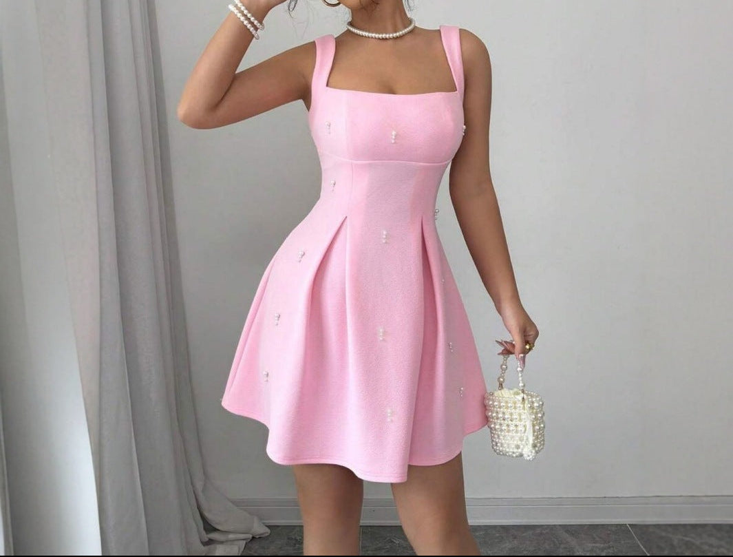 Woman wearing a pink dress with a plain background