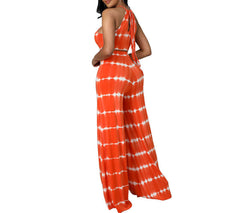 Woman wearing an orange and white tie-dye jumpsuit on a white background