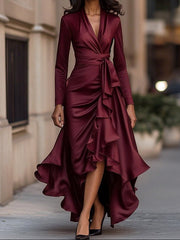 Woman wearing a burgundy dress with ruffled layers on a city street.