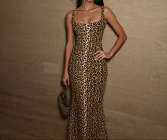 Woman wearing a leopard print dress against a beige wall