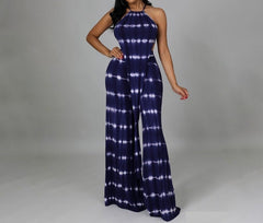 Woman wearing a blue tie-dye jumpsuit on a gray background