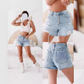 Woman wearing light blue denim shorts with a white background