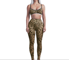 Person wearing a leopard print sports bra and leggings on a white background