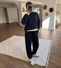 Person taking a mirror selfie in a modern room with wooden flooring and decorative elements.