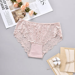 Pink lace underwear on a gray surface with flowers and a magazine.