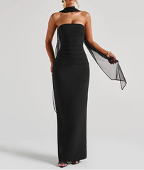Woman wearing a black strapless gown with a sheer overlay on a white background
