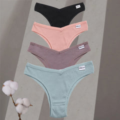 Four pairs of underwear in black, pink, purple, and green on a gray background with cotton branches.