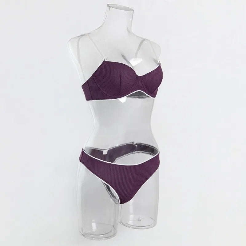 Purple bra and panties set on a clear mannequin against a white background