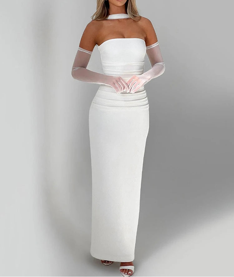 Woman wearing a white off-shoulder dress with sheer sleeves against a gray background