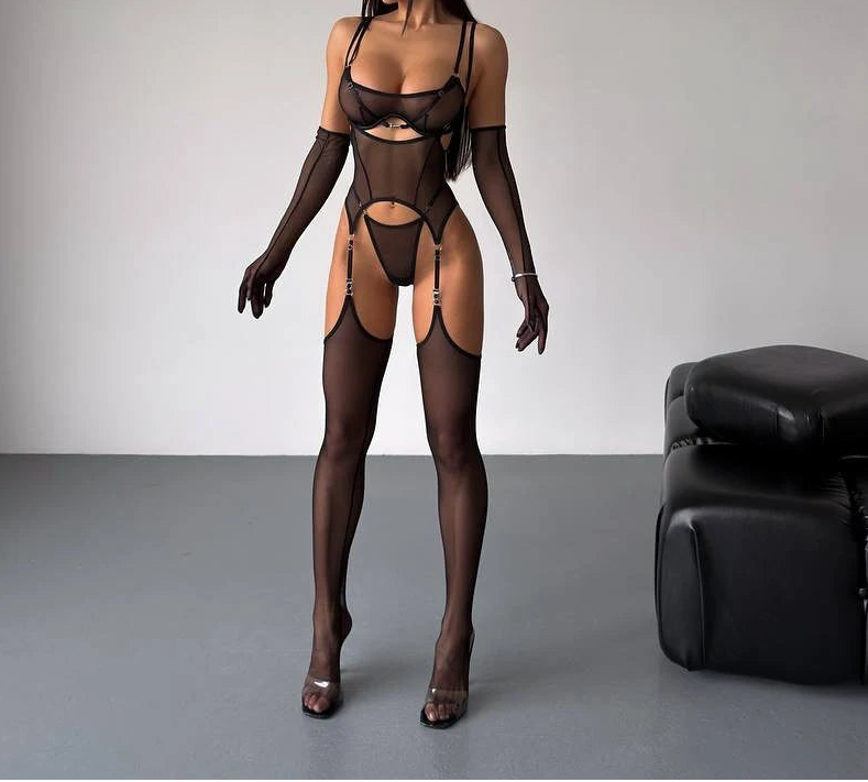 Model wearing a black lingerie set with sheer details against a neutral background.