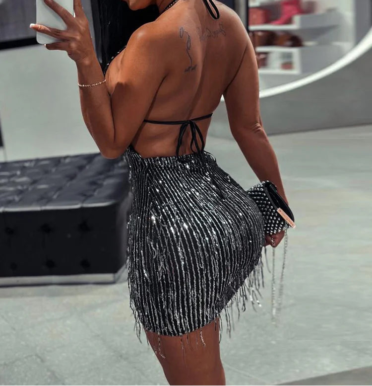 Woman taking a mirror selfie wearing a black beaded outfit.
