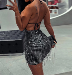 Woman taking a mirror selfie wearing a black beaded outfit.