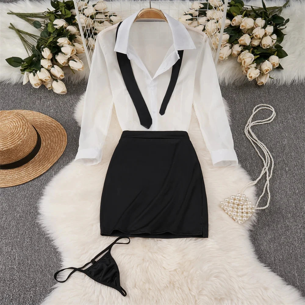 White blouse with black vest and skirt on a hanger, surrounded by flowers and accessories.