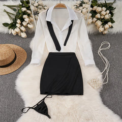 White blouse with black vest and skirt on a hanger, surrounded by flowers and accessories.