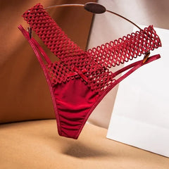 Red bikini with mesh design on a beige surface