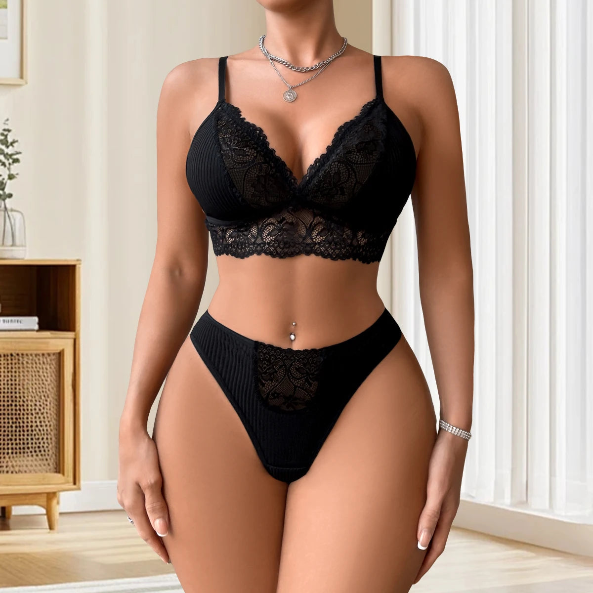 Black lace lingerie set worn by a model in a neutral setting