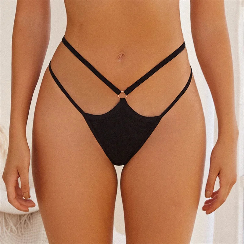 Black bikini bottom on a person against a neutral background