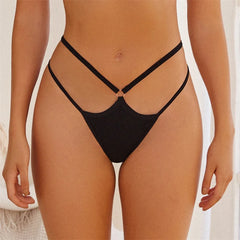 Black bikini bottom on a person against a neutral background