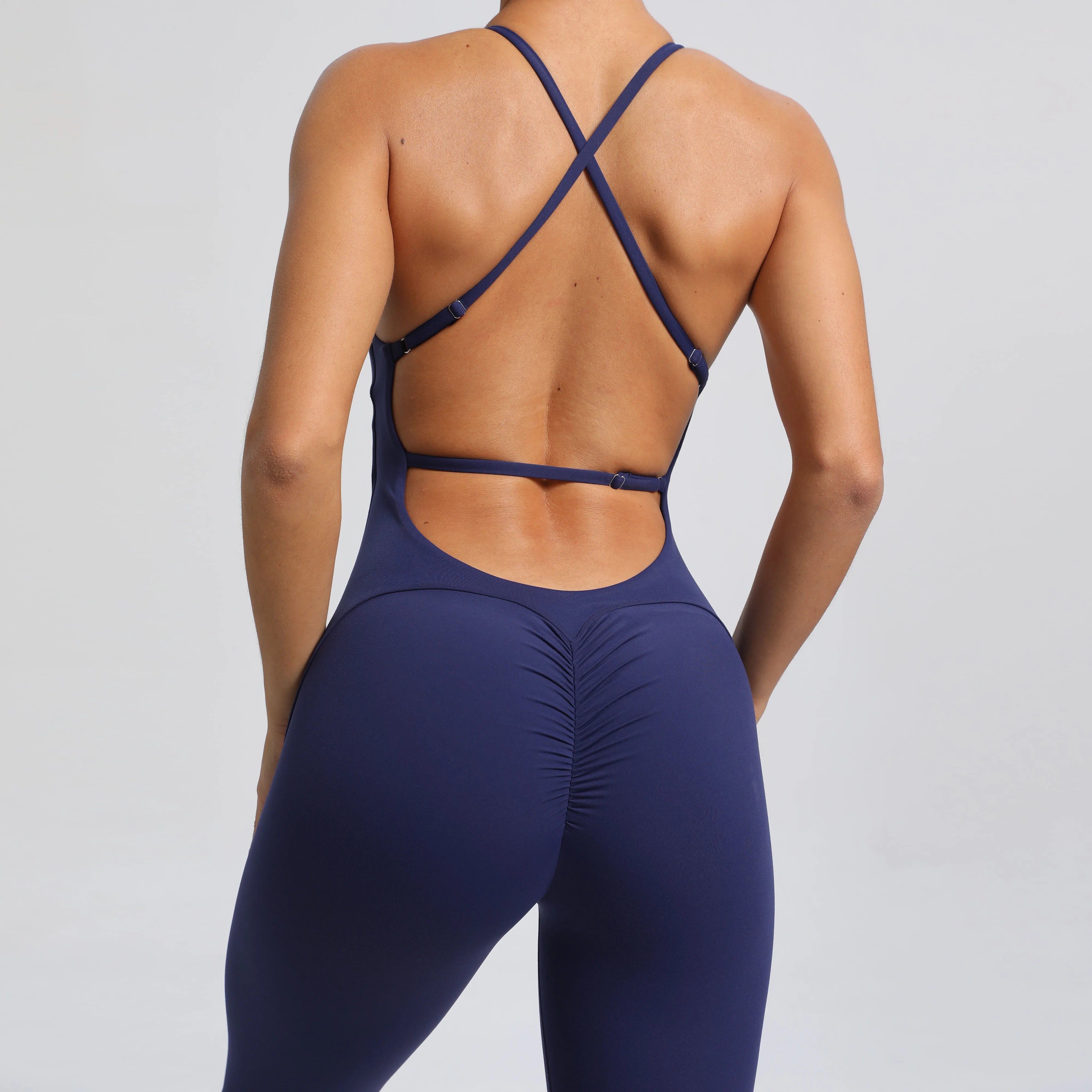 Navy blue strappy top and leggings on a plain background
