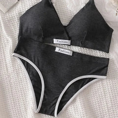 Black bikini set with 'Fashion' labels on a textured white surface