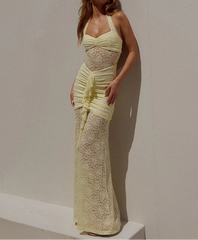 Woman wearing a light yellow lace dress against a plain background