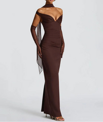 Woman wearing a brown evening gown with sheer sleeves on a white background