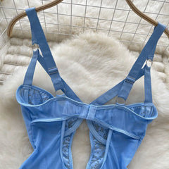 Blue lace lingerie set on a hanger against a white textured background