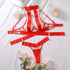 Red lingerie set on a white surface with flowers and jewelry.