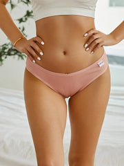 Person wearing pink underwear with a blurred background