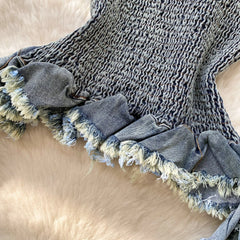Textured blanket with frayed edges on a beige surface
