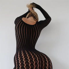 Person wearing a black and brown patterned dress against a plain background