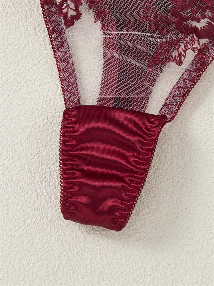 Close-up of red lace fabric with satin trim on a white background