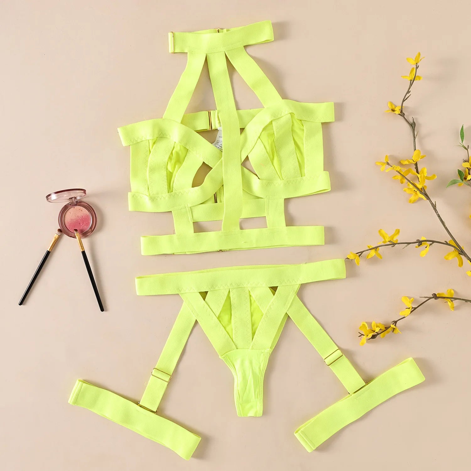Neon green strappy lingerie set on a beige background with makeup and flowers.