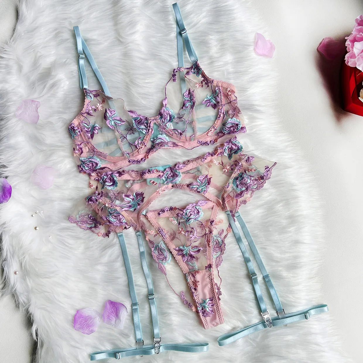 Floral lingerie set with garter on a fluffy white surface