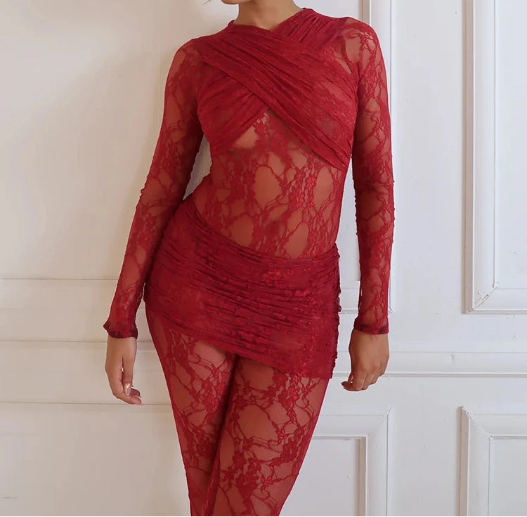 Woman wearing a red lace dress against a white wall