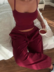 Person wearing a burgundy outfit sitting on a bed holding a small bowl.
