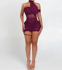 Woman wearing a burgundy dress with sheer panels on a white background