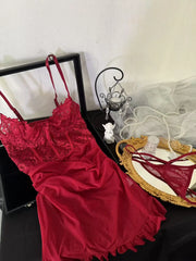 Red lace lingerie set on a table with decorative items.