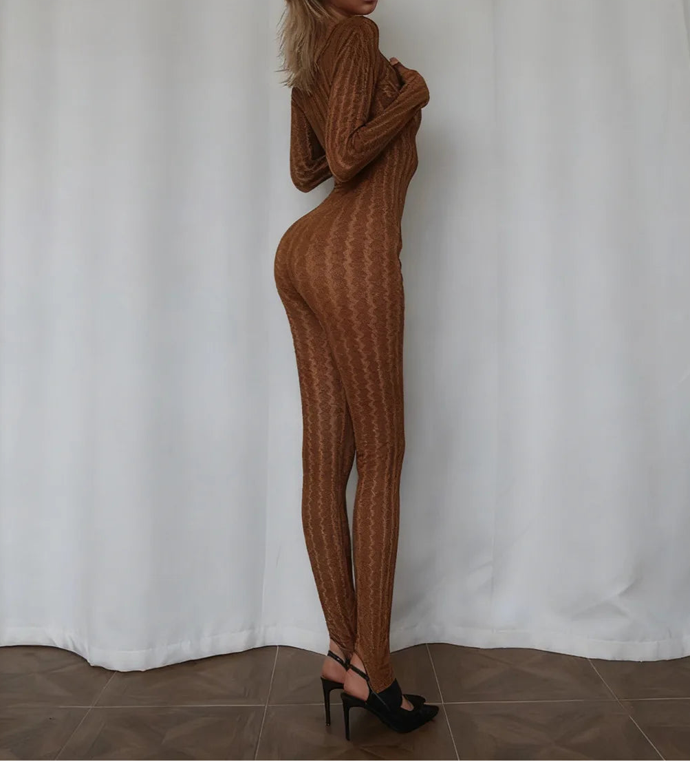 Woman wearing a brown ribbed knit outfit standing against a white curtain.