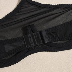 Close-up of a black swimsuit with a strap on a beige background