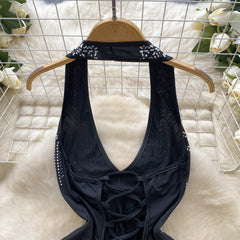 Black lace top on a hanger with a white floral background