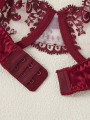 Red lace lingerie set on a textured beige background