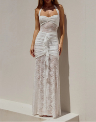 Woman wearing a white lace dress against a plain background