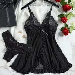 Black lace lingerie set on a white surface with red roses and jewelry.