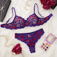 Purple lingerie set with red heart and lip designs on a white fabric background.