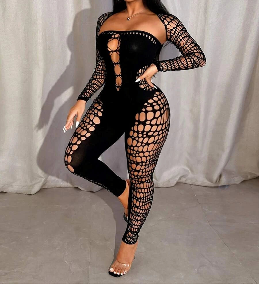 Woman wearing a black lace jumpsuit against a white curtain background