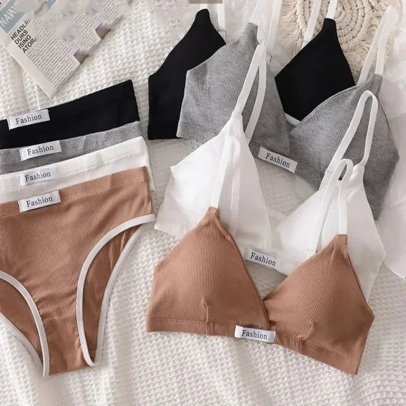 Collection of women's underwear including bras and panties on a textured surface.