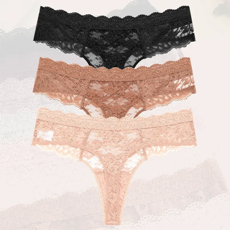 Three pairs of lace underwear in black, rose gold, and pink on a textured gray background.