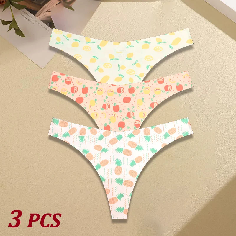 Three pairs of women's underwear with pineapple and fruit patterns on a beige surface.