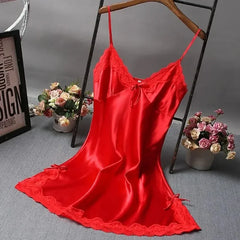 Red satin slip dress on a hanger with flowers and a frame in the background